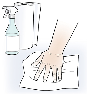 Hand wiping surface with paper towel.